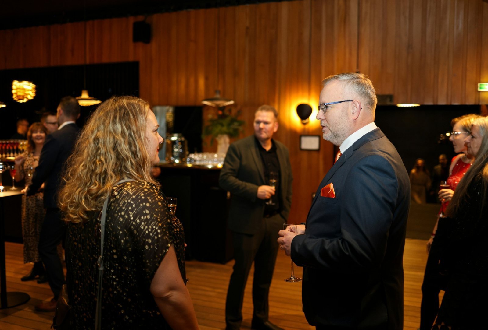 Guests in conversation at a private evening gathering